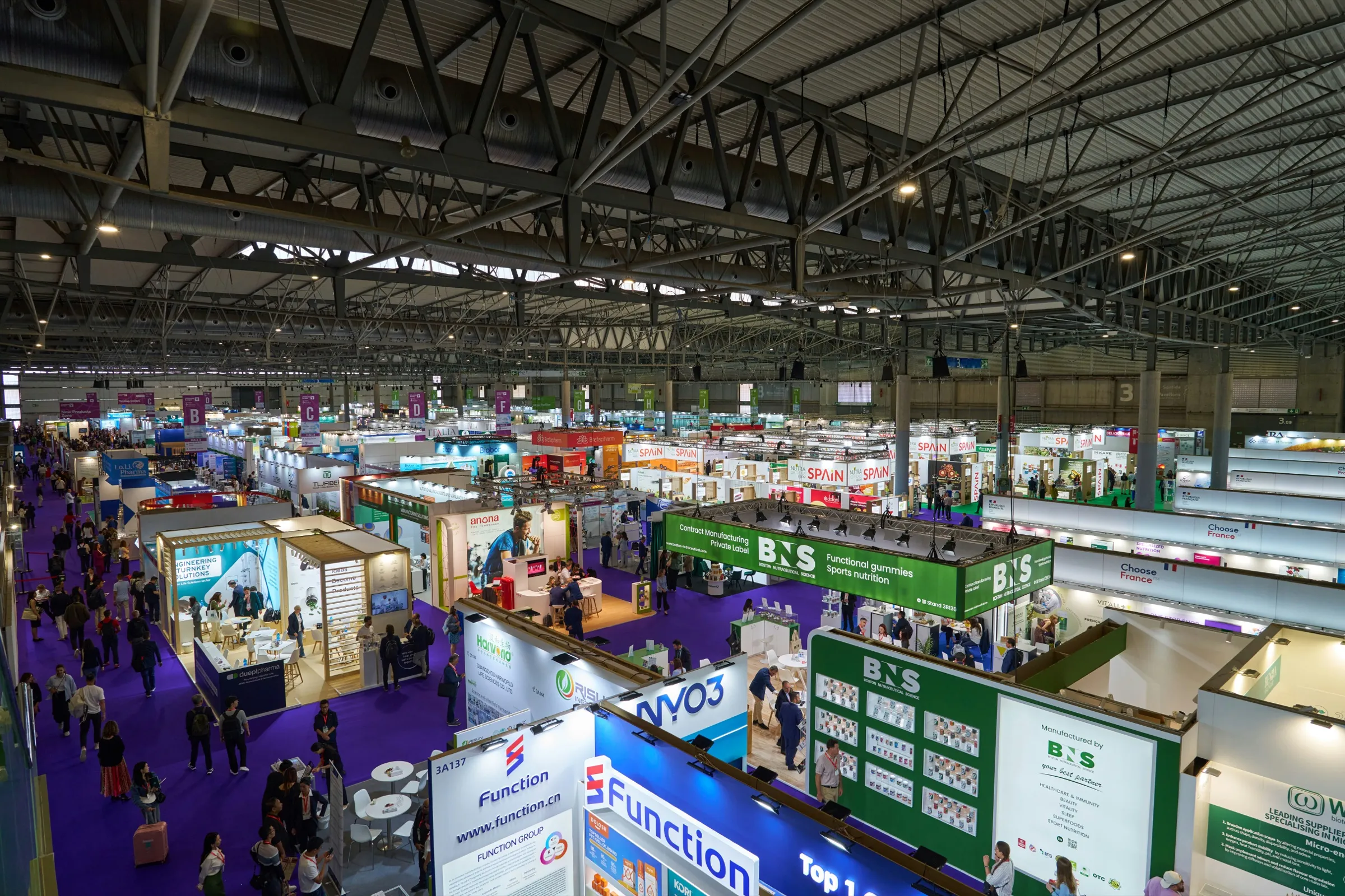 Hall d'exposition rempli de stands et de visiteurs